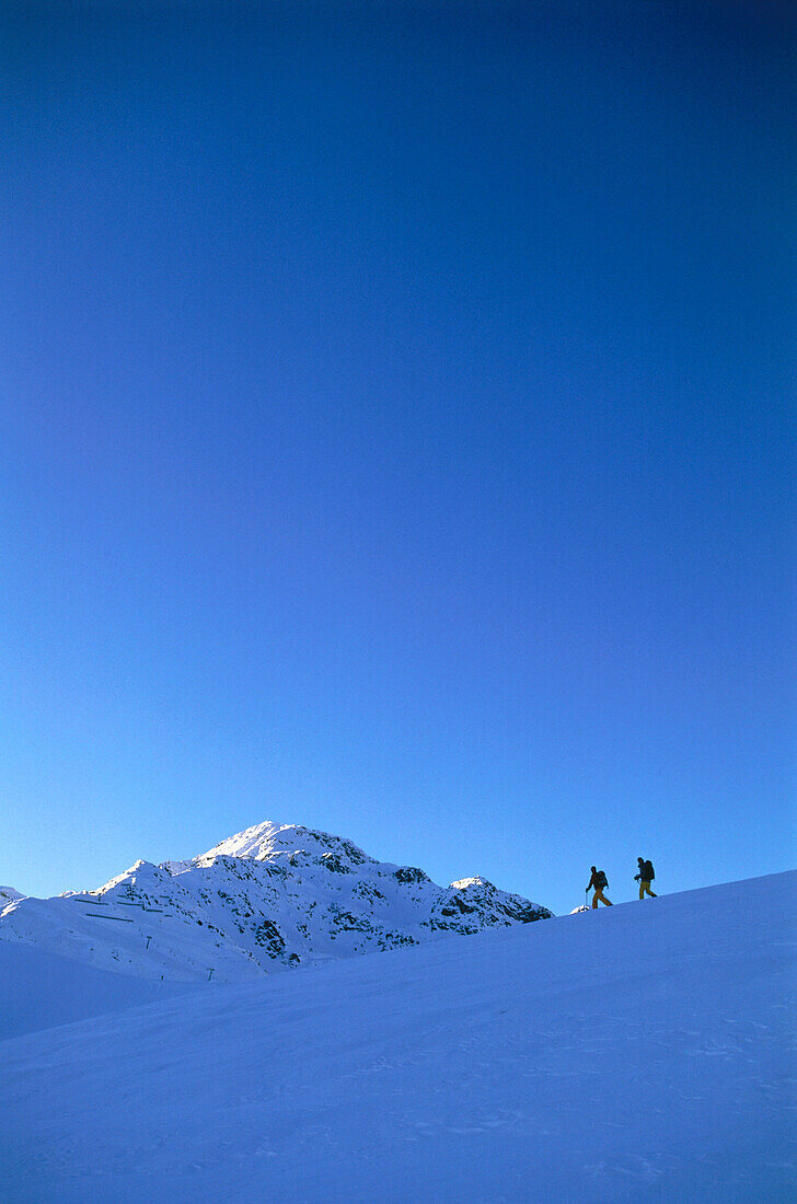Two people snowshoeing through a winter landscape, Serfaus, Tyrol, Austria