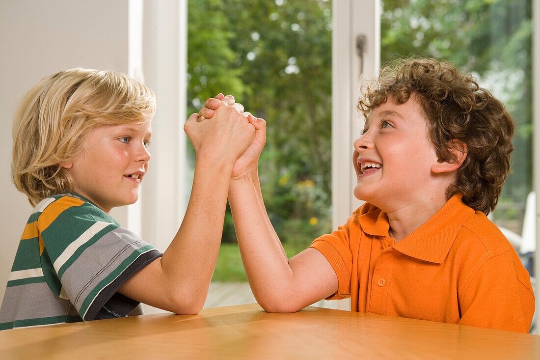 Two boys arm wrestling, children's birthday party
