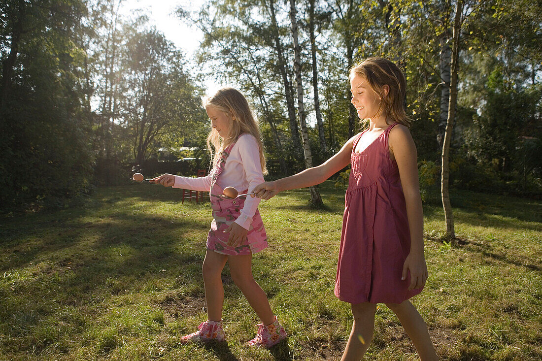 Zwei Mädchen spielen Eierlaufen, Kindergeburtstag