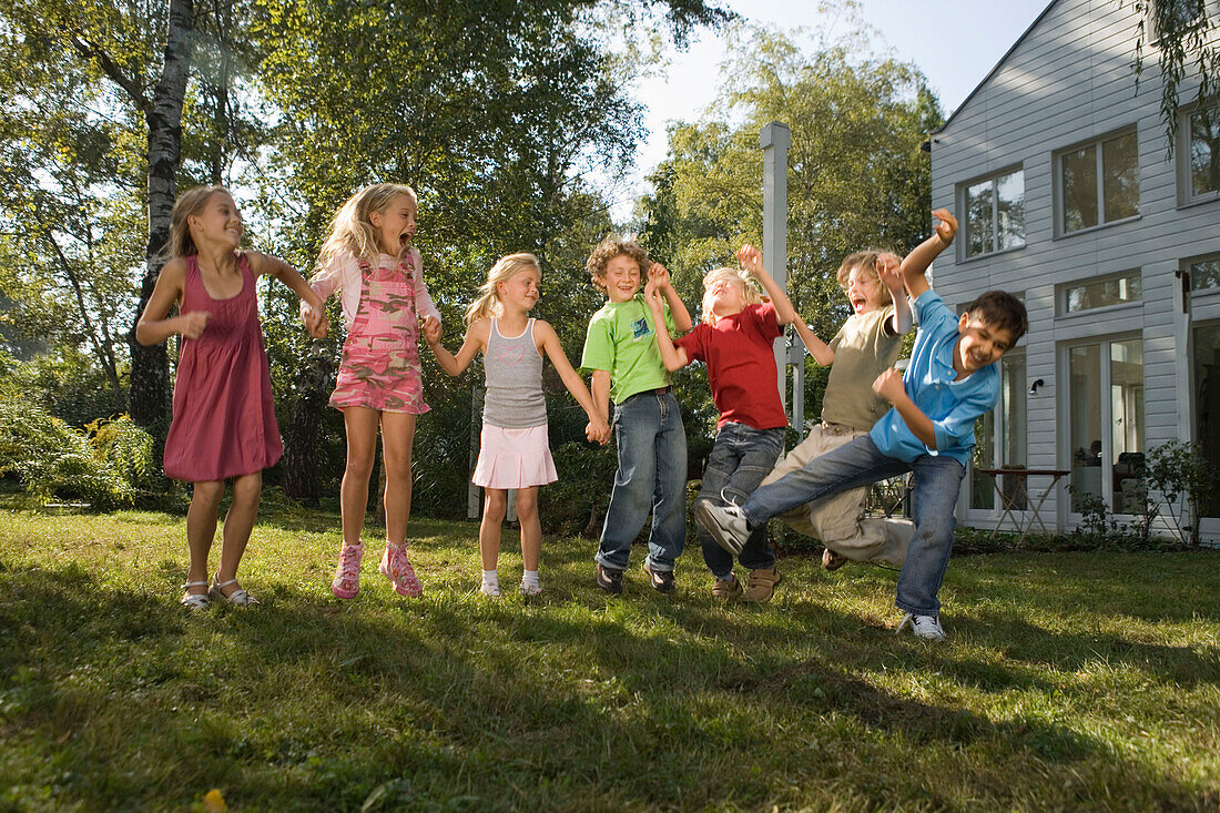 Children holding hands and jumping, children's birthday party
