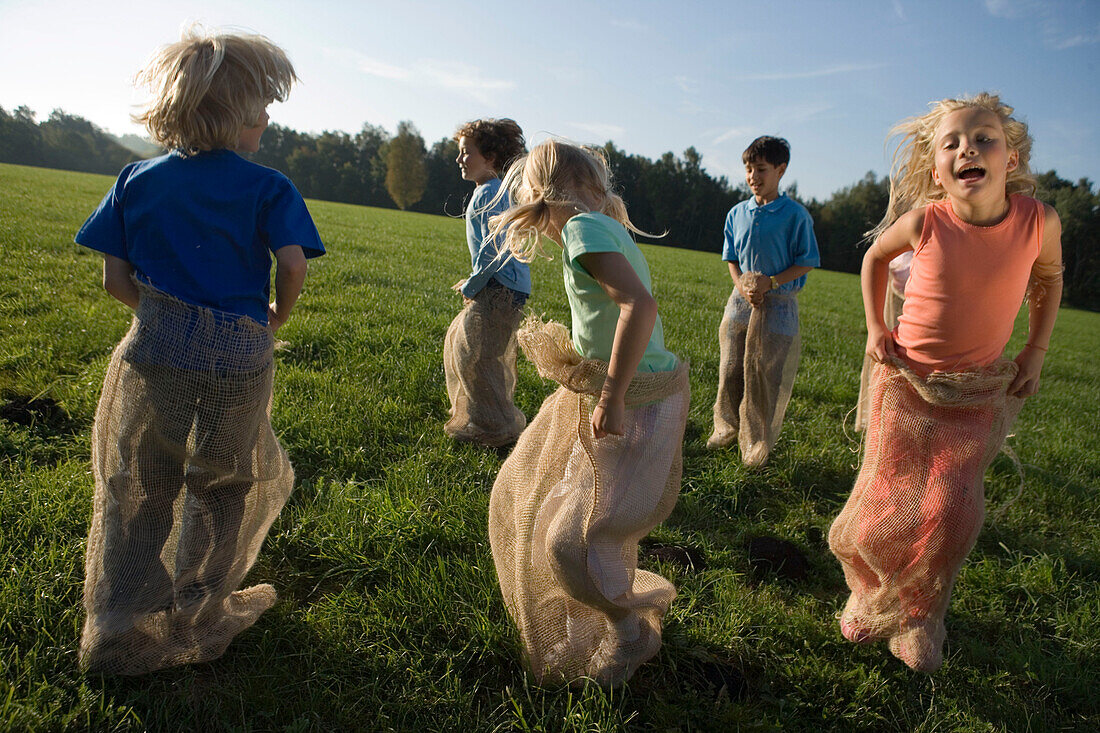 Group of children having a sack race, children's birthday party