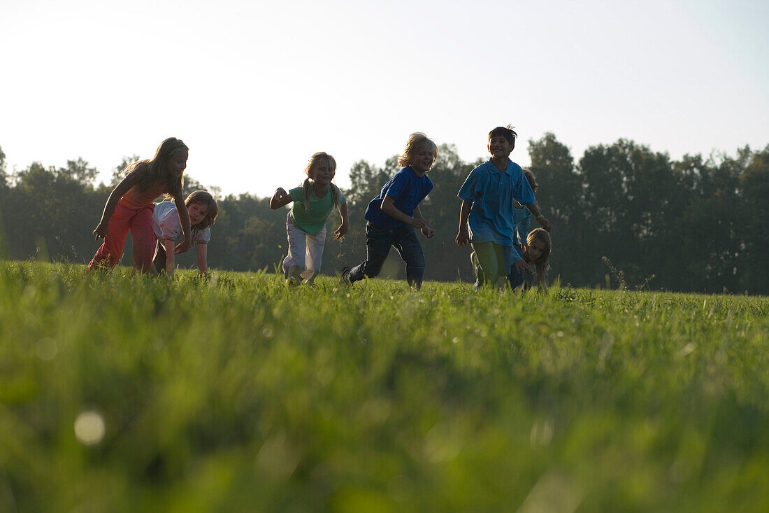 Children running over field, children's birthday party