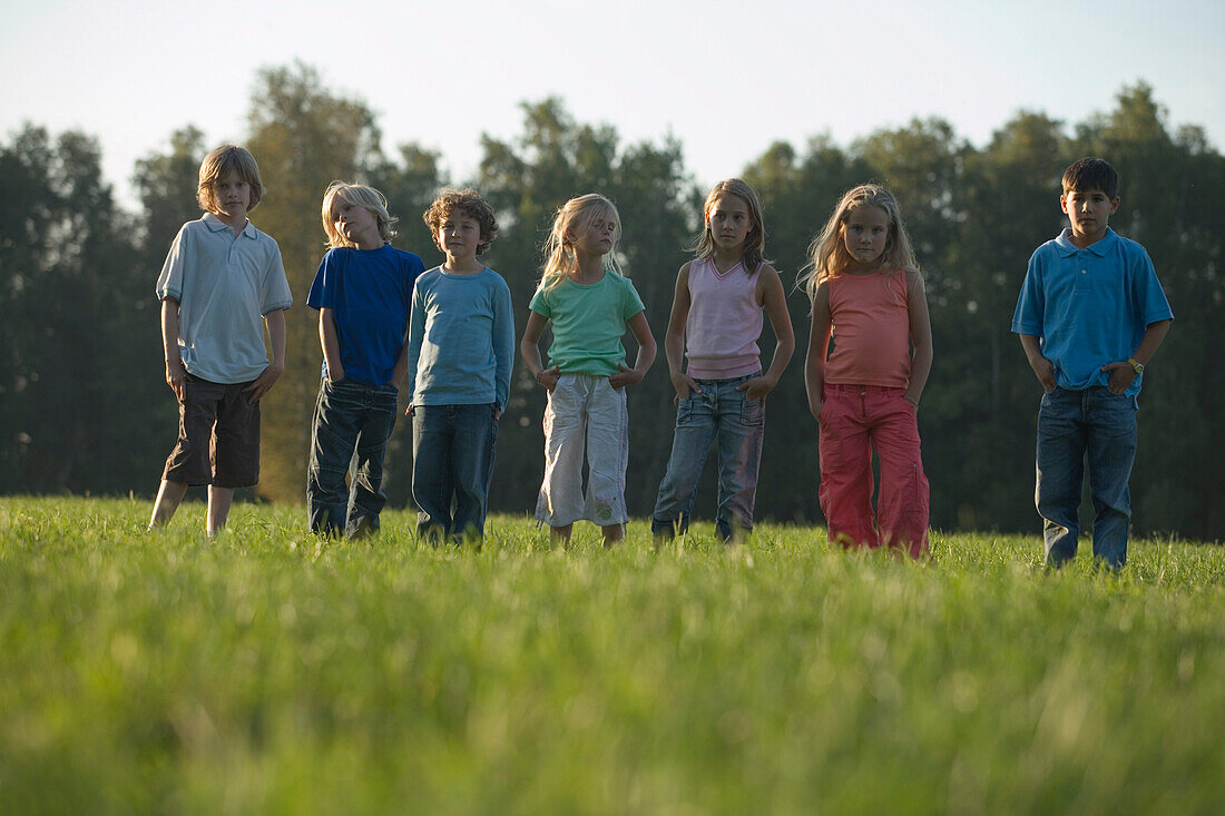 Kinder stehen nebeneinander auf einer Wiese, Kindergeburtstag