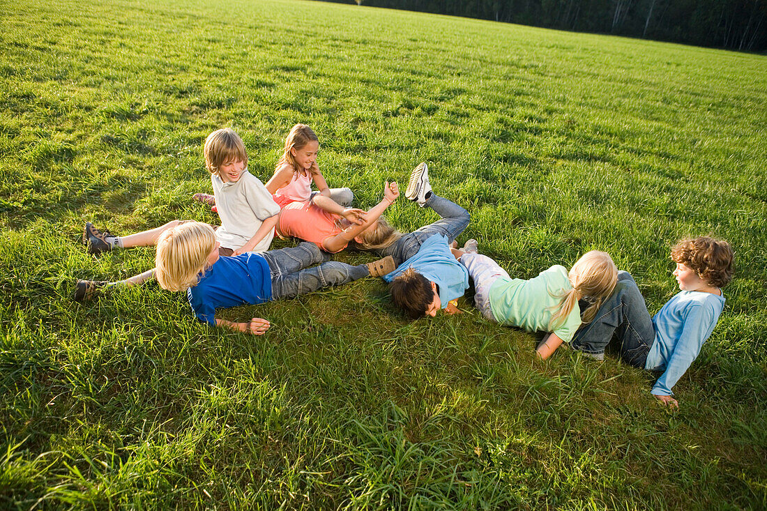 Kinder spielen ausgelassen auf einer Wiese, Kindergeburtstag