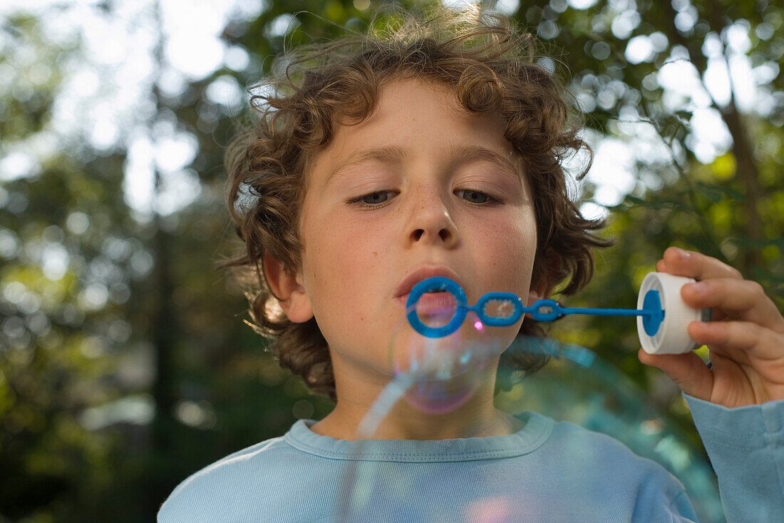 Junge macht Seifenblasen, Kindergeburtstag