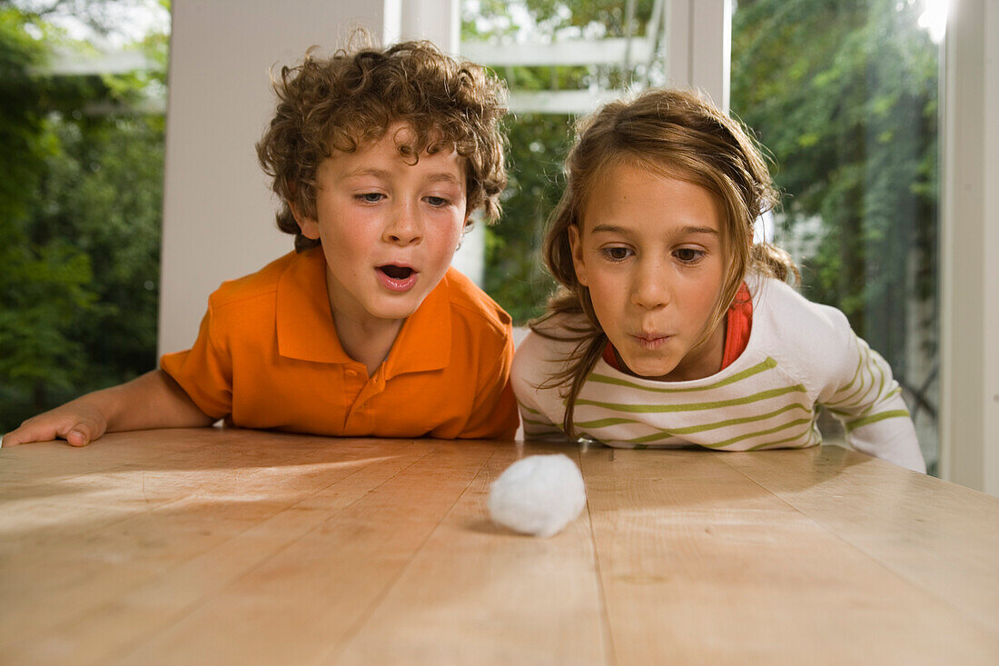 Ein Mädchen und ein Junge spielen Wattebausch Blasen, Kindergeburtstag
