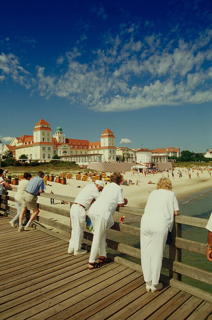 Vacationers standing on beach bridge and looking over beach and spa hotel, Binz, Ruegen, Mecklenburg-Western Pomerania, Germany