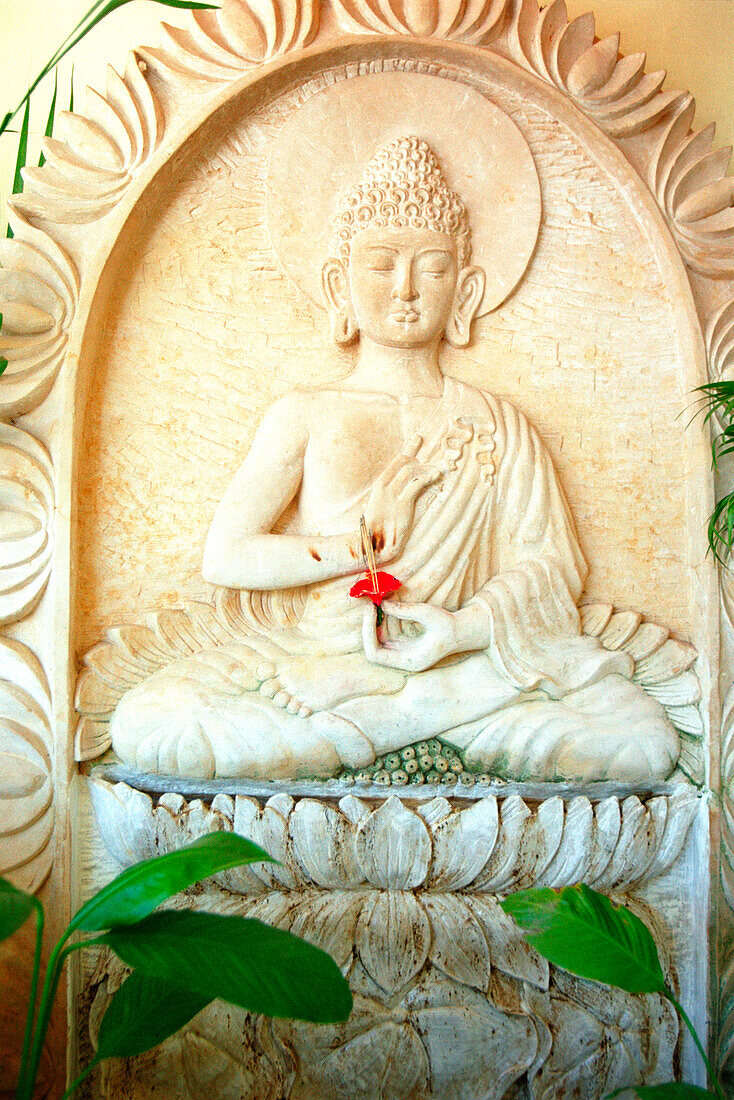 Relief von Buddha im Lotussitz mit Hibiskusblüte, Ubud, Bali, Indonesien