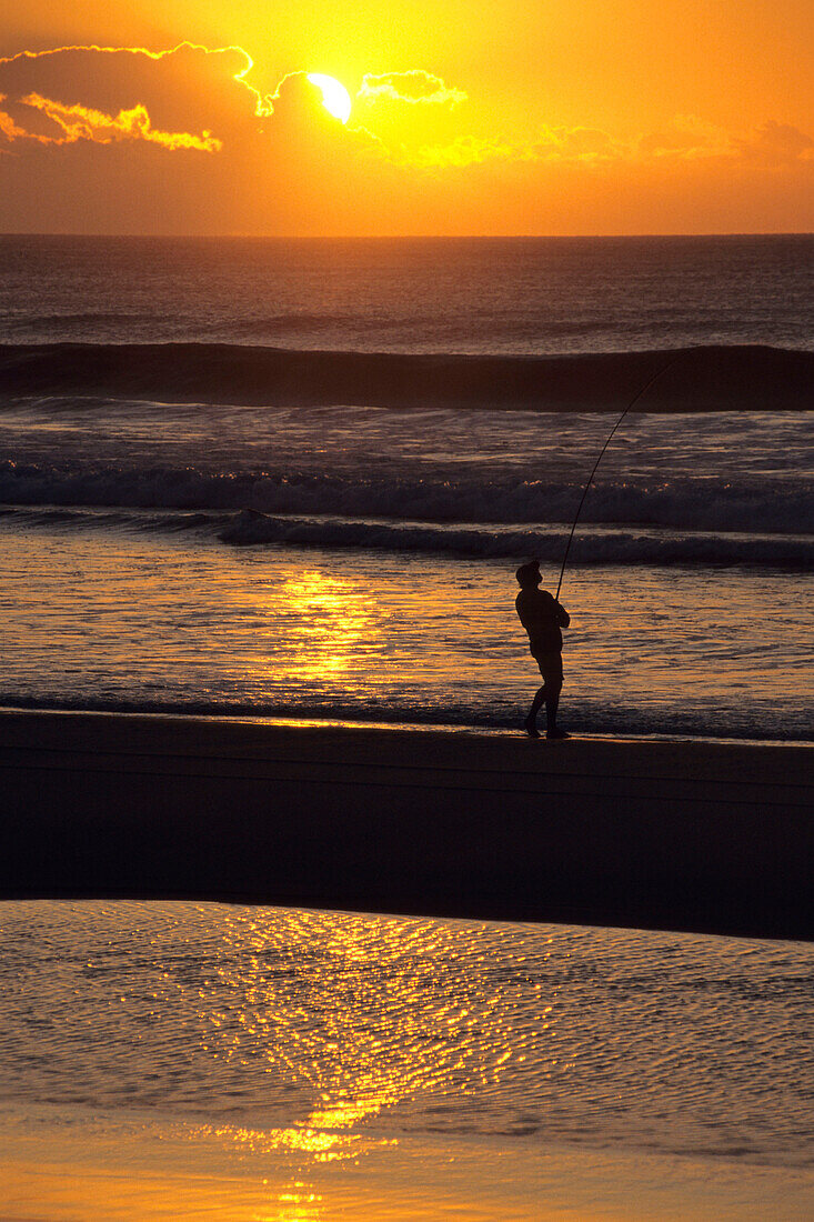 Ein Fischermann bei Sonnenaufgang, Fraser Island, Queensland, Australien