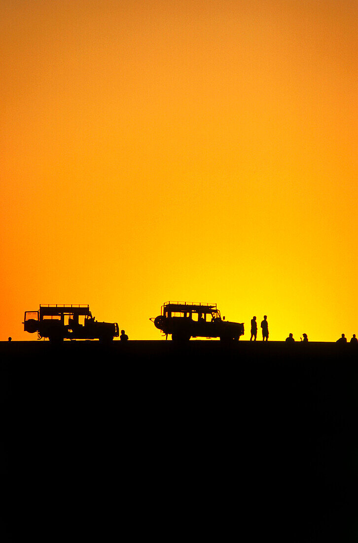 Touristengruppe beim Sonnenuntergang, Geländewagen auf Düne, bei Walvis Bay, Namibia, Afrika