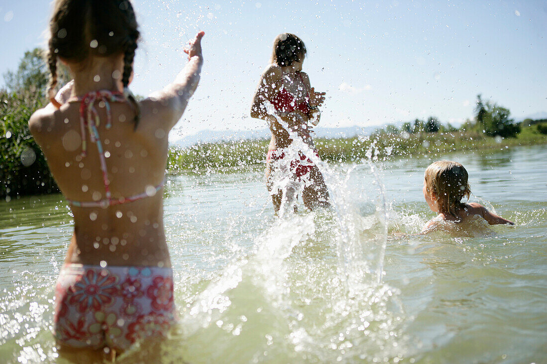 Mutter und Kinder haben Spaß im Wasser, Fohnsee, Osterseen, Oberbayer, Deutschland