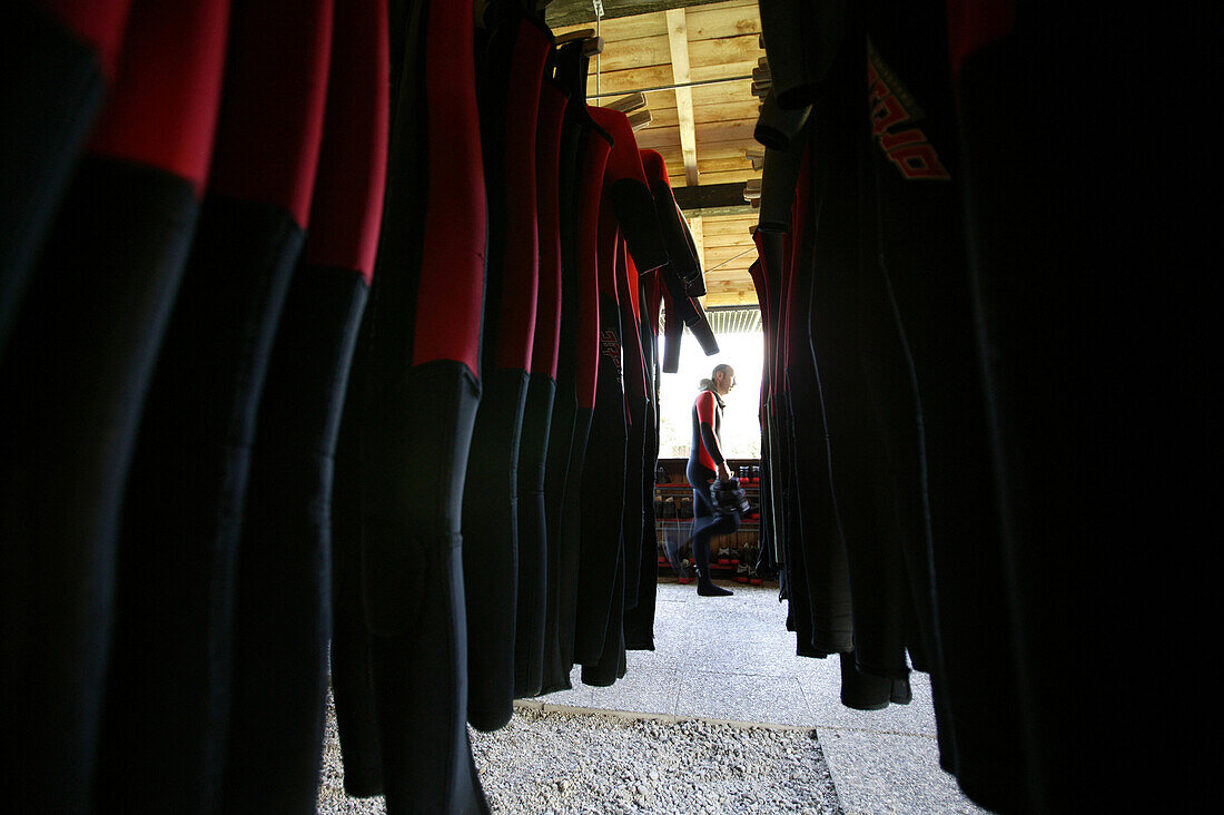 A man going canyoning and wetsuits hung-up in a row, Haiming, Tyrol, Austria