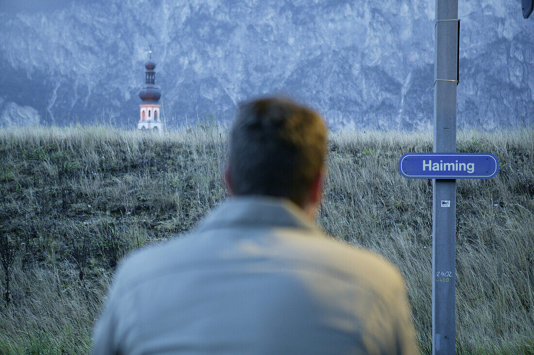 Man waiting for a train at Haiming station, Tyrol, Austria