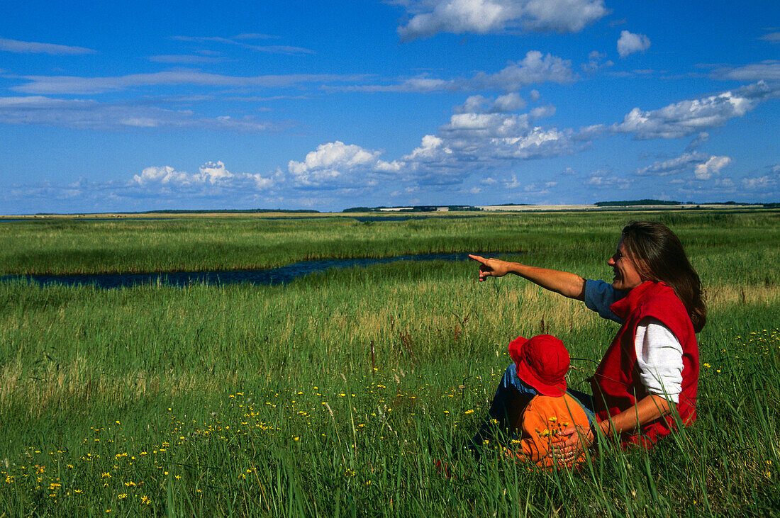 Woman and child sitting on Sundische Wiese, National Park, Zingst, Mecklenburg-Western Pomerania, Germany