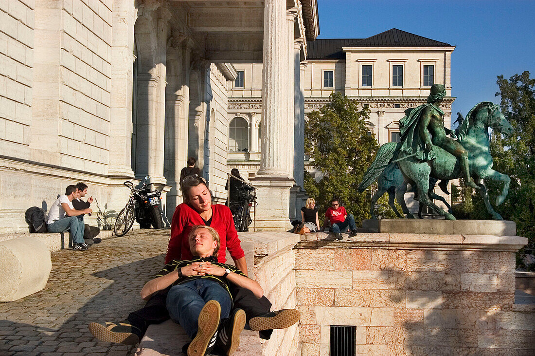 Paare sitzen vor der Akademie der Bildenden Künste, München, Bayern, Deutschland