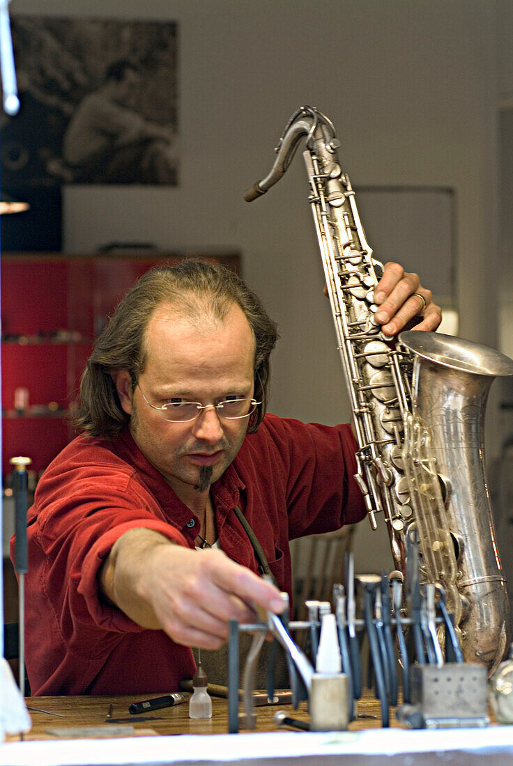 Mann repariert Saxophon, München, Bayern, Deutschland