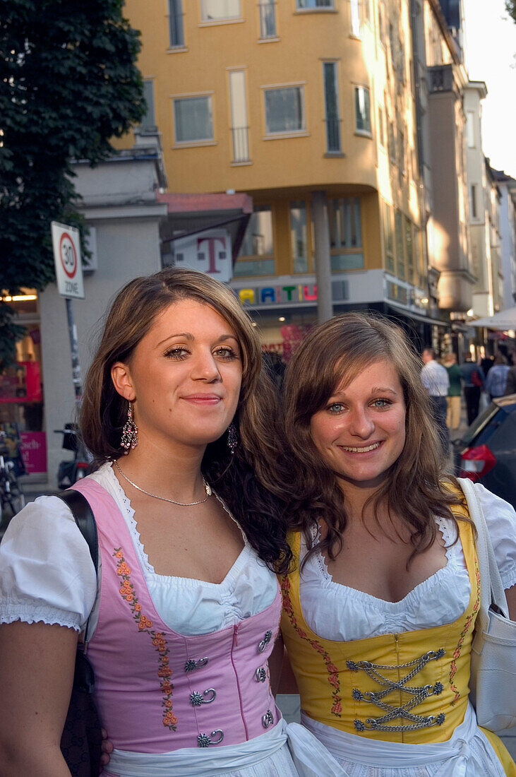 Girls wearing traditional Bavarian style dresses called Dirndl, Leopold Street, Schwabing, Munich, Bavaria, Germany
