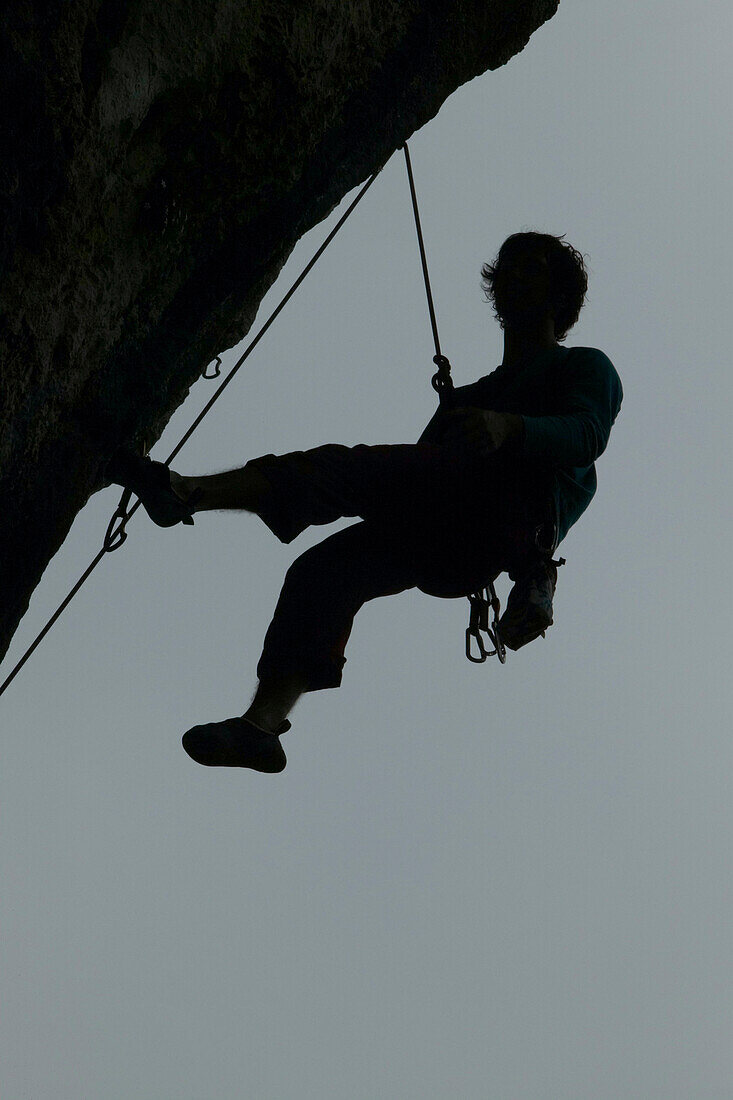 Mann, Kletterer, Überhang hängt am Seil, Ceredo, Gardasee, Italien