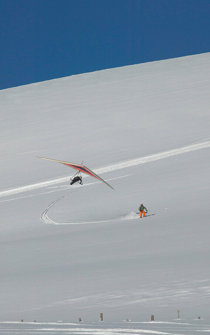 Drachenflieger und Skifahrer am Falkertsee, Kärnten, Österreich
