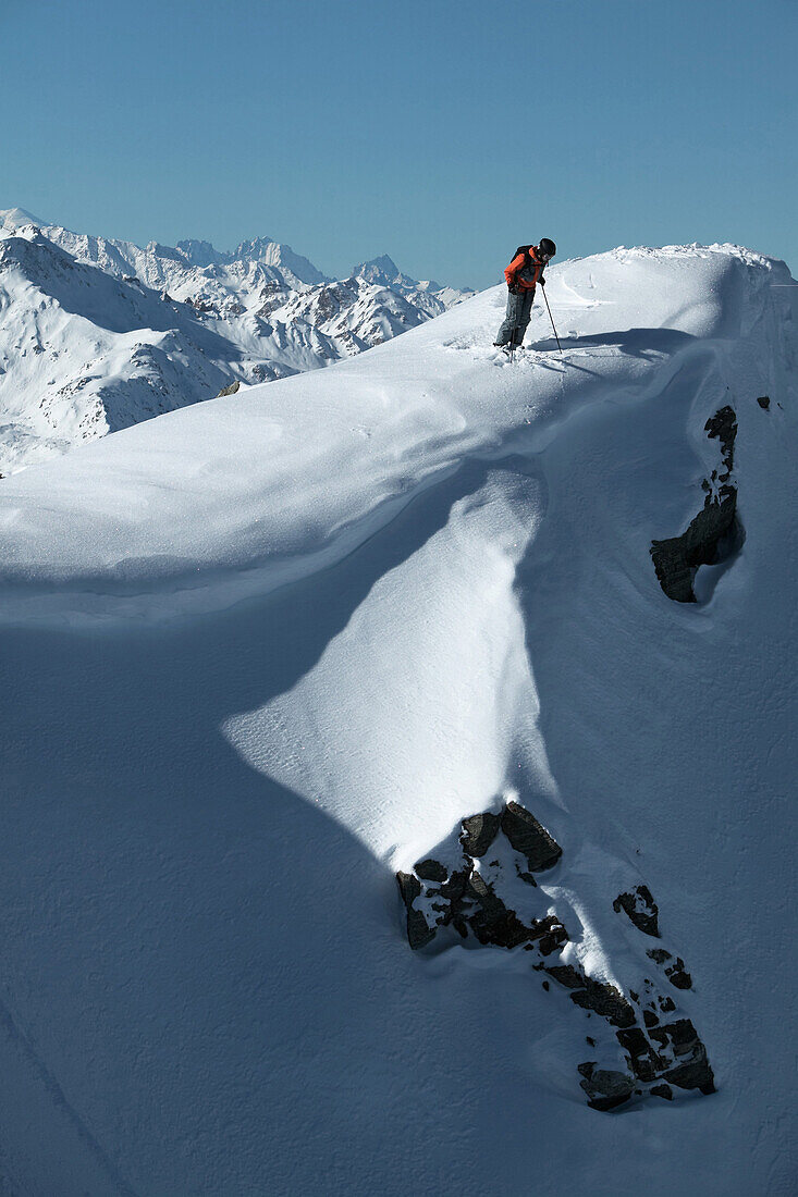 Skifahrer steht auf verschneitem Berg, Skigebiet Chandolin und Saint-Luc, Kanton Wallis, Schweiz