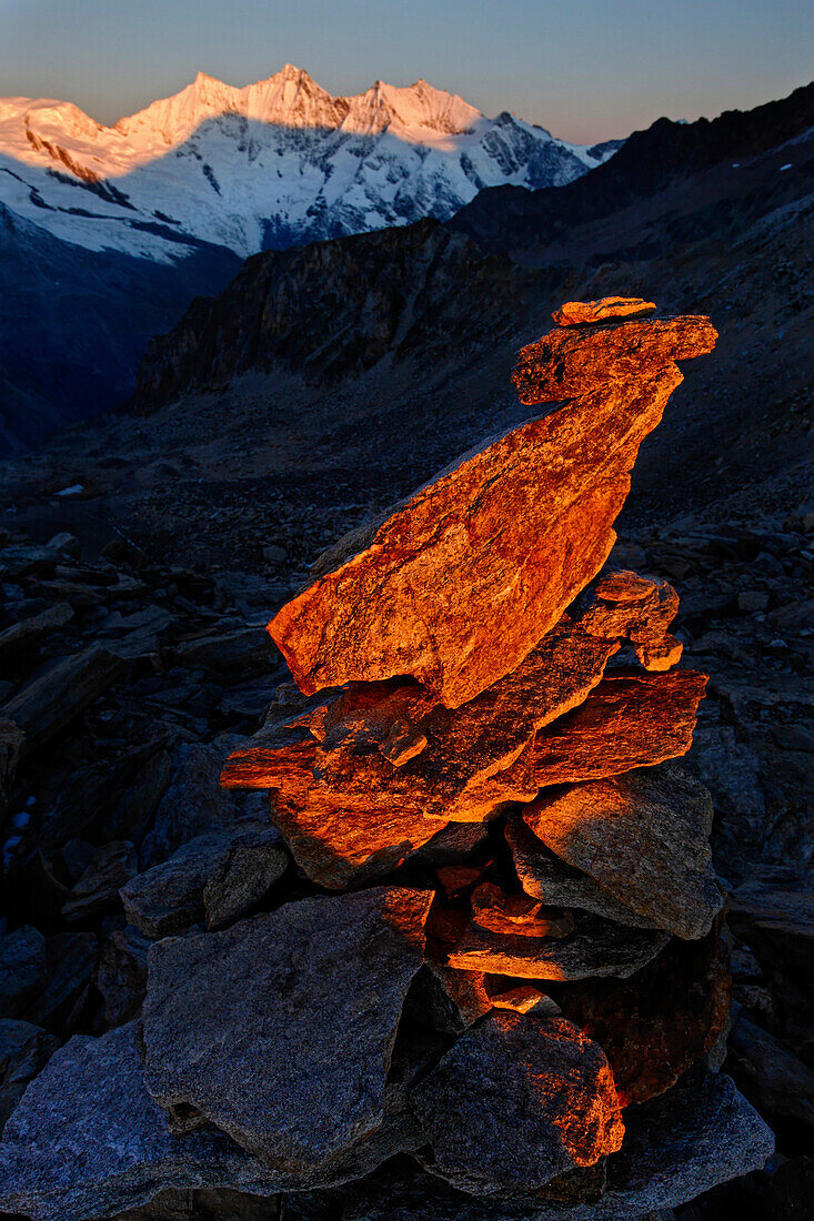 Canton Valais, a cairn at sunrise at the Zwischenbergpass on the way to the Weissmies (4017 m). In the background the fourthausend meter peaks of the Mischabel: Alphubel, Taeschhorn, Dom, Lenzspitze, Nadelhorn, canton Valais,Switzerland, Europe
