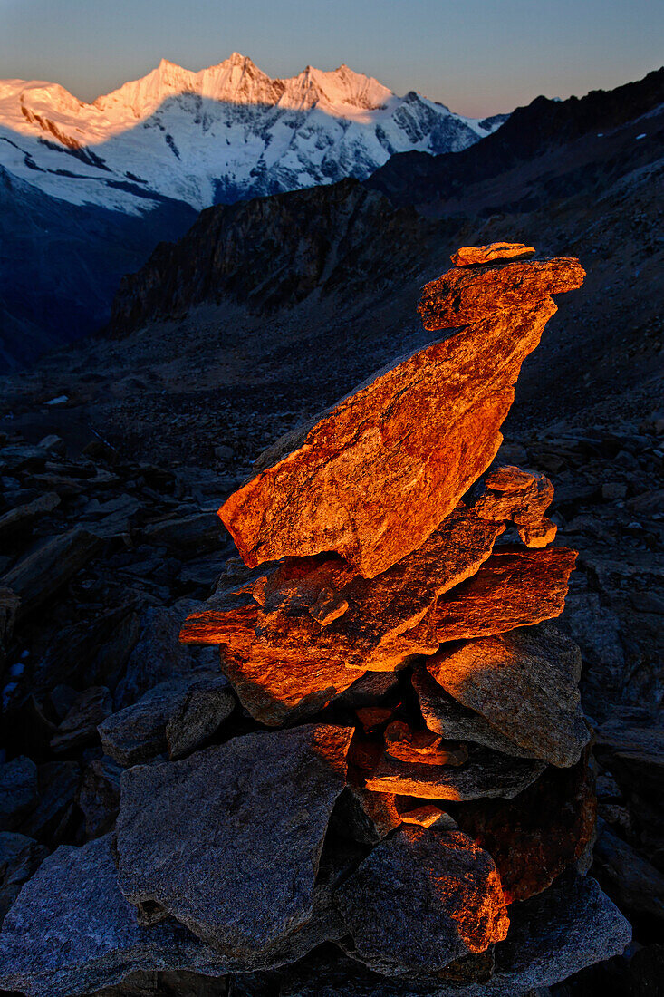 Wallis, Schweiz, Ein Steinmann im Sonnenaufgang auf dem Zwischenbergpass unterwegs zum Weissmiesgipfel. Im Hintergrund die Viertausender der Mischabelgruppe: Alphubel, Taeschhorn, Dom, Lenzspitze, Nadelhorn. Weissmies, Allmagell,  Alpen.