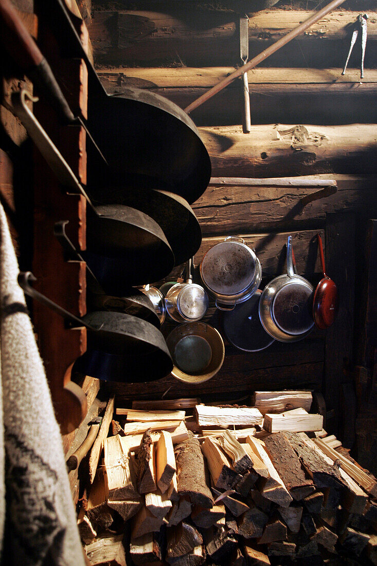Frying pans and cooking pots with Woodpiles, Restaurant Karseggalm, Salzburger Land, Austria