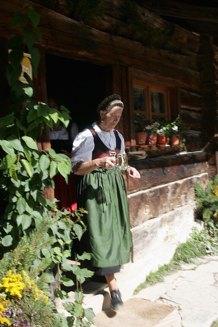 Mature woman serving juice,Restaurant Maurachalm, Nationalpark Hohe Tauern, Salzburger Land, Austria