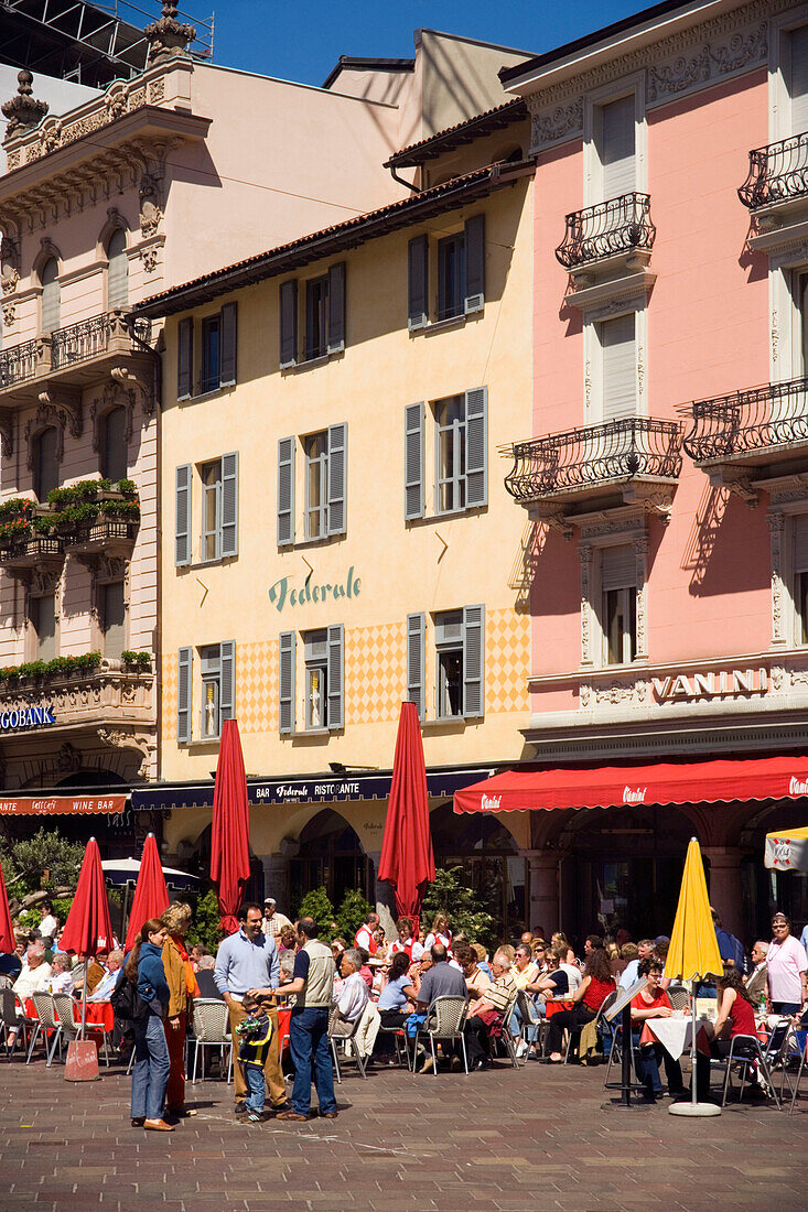 People sitting in a pavement cafea Piazza della Riforma, Lugano, Lake Lugano, Ticino, Switzerland