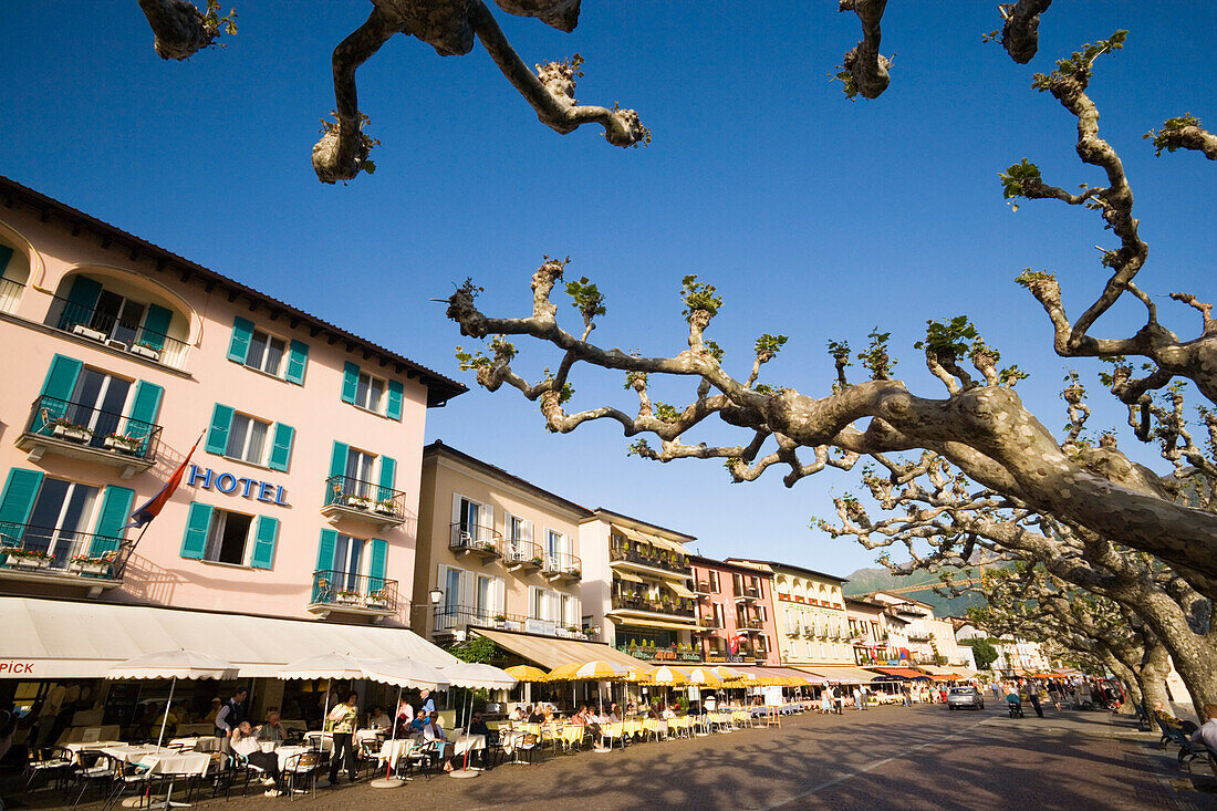Leute an der Hafen Promenade mit Straßencafes und Hotel Mövenpick Albergo Carcani, Ascona, Lago Maggiore, Tessin, Switzerland
