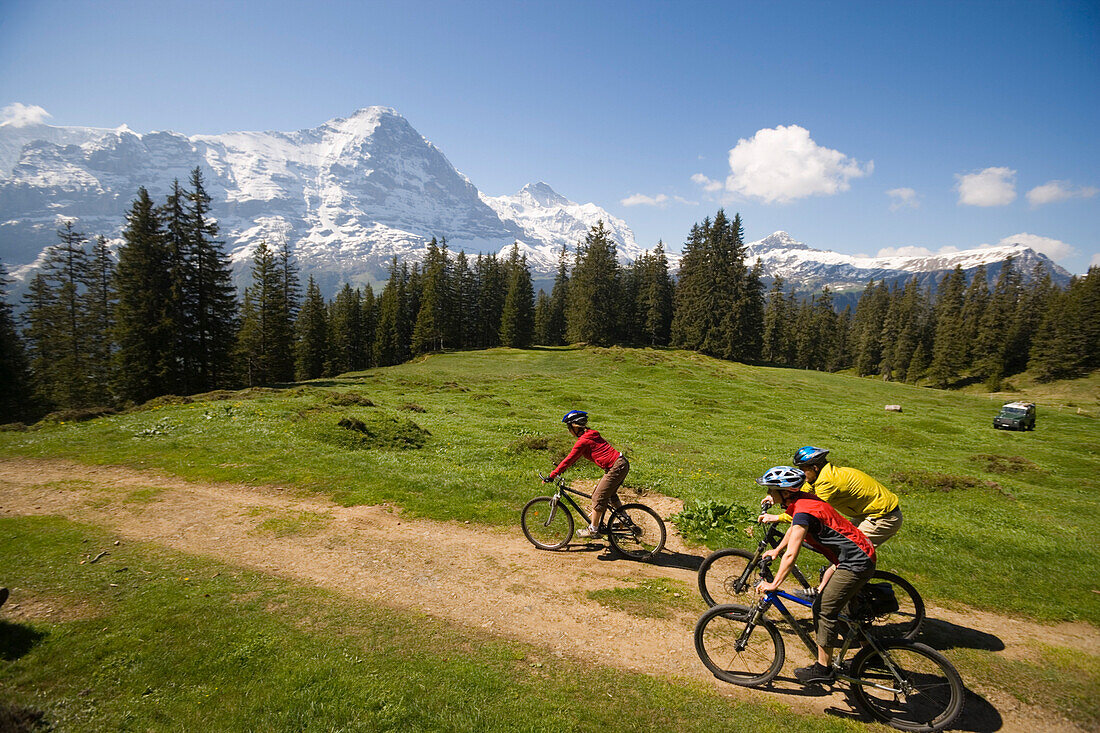 Drei Leute auf eine Mountainbike Tour, Bussalp 1800 m, Blick zu Eiger Nordwand 3970 m, Grindelwald, Berner Oberland, Kanton Bern, Schweiz