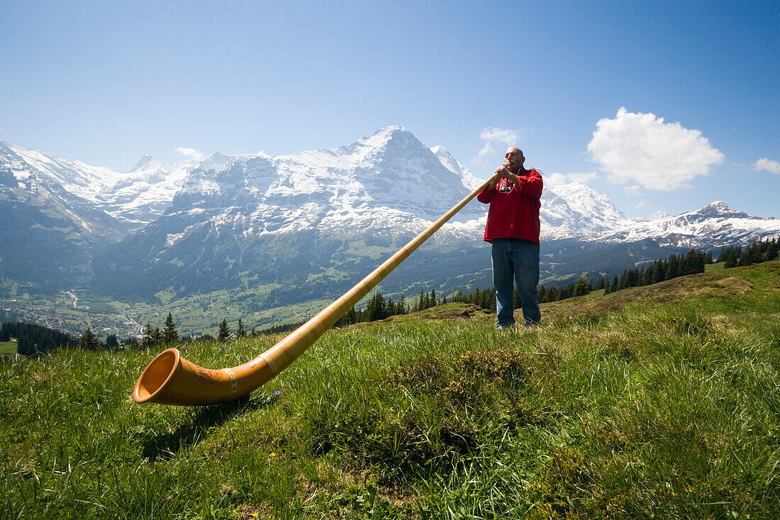 Man playing an alphorn at Bussalp 1800 m, Grindelwald, Bernese Oberland, Canton of Bern, Switzerland