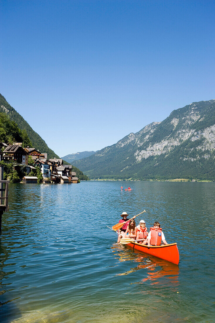 Children in a canoe, lake Hallstatt, Hallstatt, Salzkammergut, Upper Austria, Austria