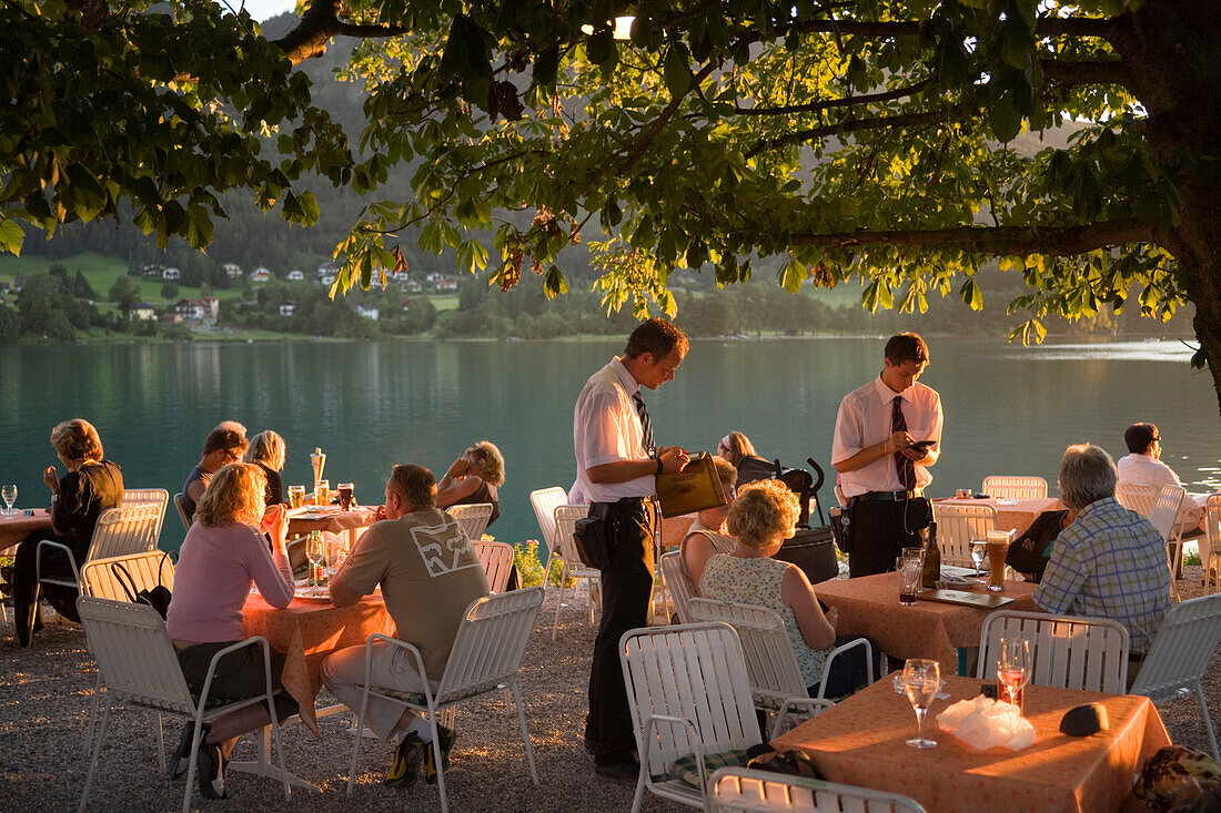 Waiters taking order for guests in the open air area of a restaurant, Lake Fuschl, Fuschl am See, Salzkammergut, Salzburg, Austria