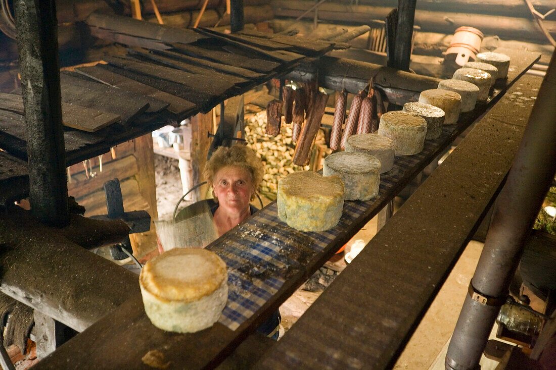 A woman, dairymaid, checking curd cheese, Knetkäse, during the smoking process, traditional cheese production, Karseggalm 1603 m, one of the oldest mountain huts in the valley, Grossarl Valley, Salzburg, Austria