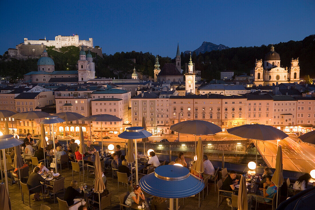 Blick über die beleuchtete Dachterrasse des Restaurant Hotels Stein abends, Richtung Altstadt mit Salzburger Dom, Klosterkirche St. Peter, Franziskanerkirche und Festung Hohensalzburg der größte erhaltene Festungsbau Mitteleuropas, Salzburg, Salzburg, Öst