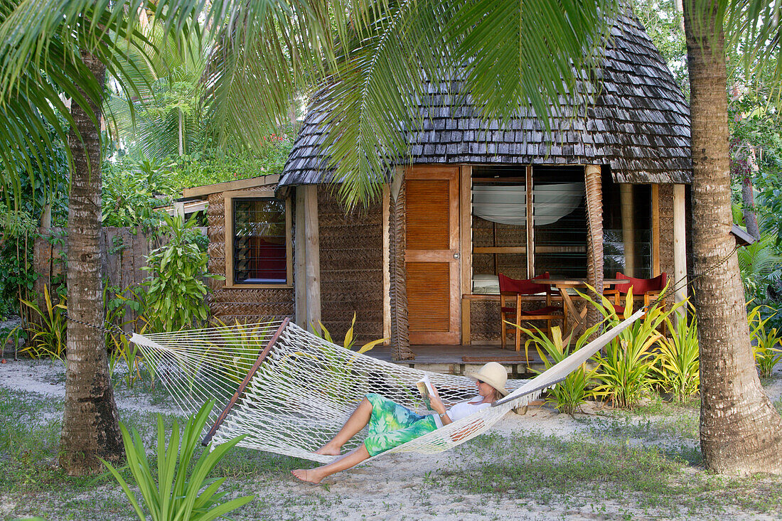 Woman reading in Hammock, Tonga, South Seas