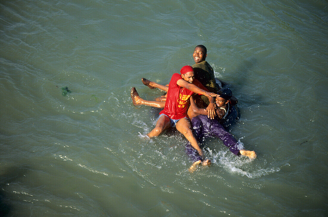 Young men going down Rio San Juan close to Hato Nuevo in the San Juan Valley with a tube