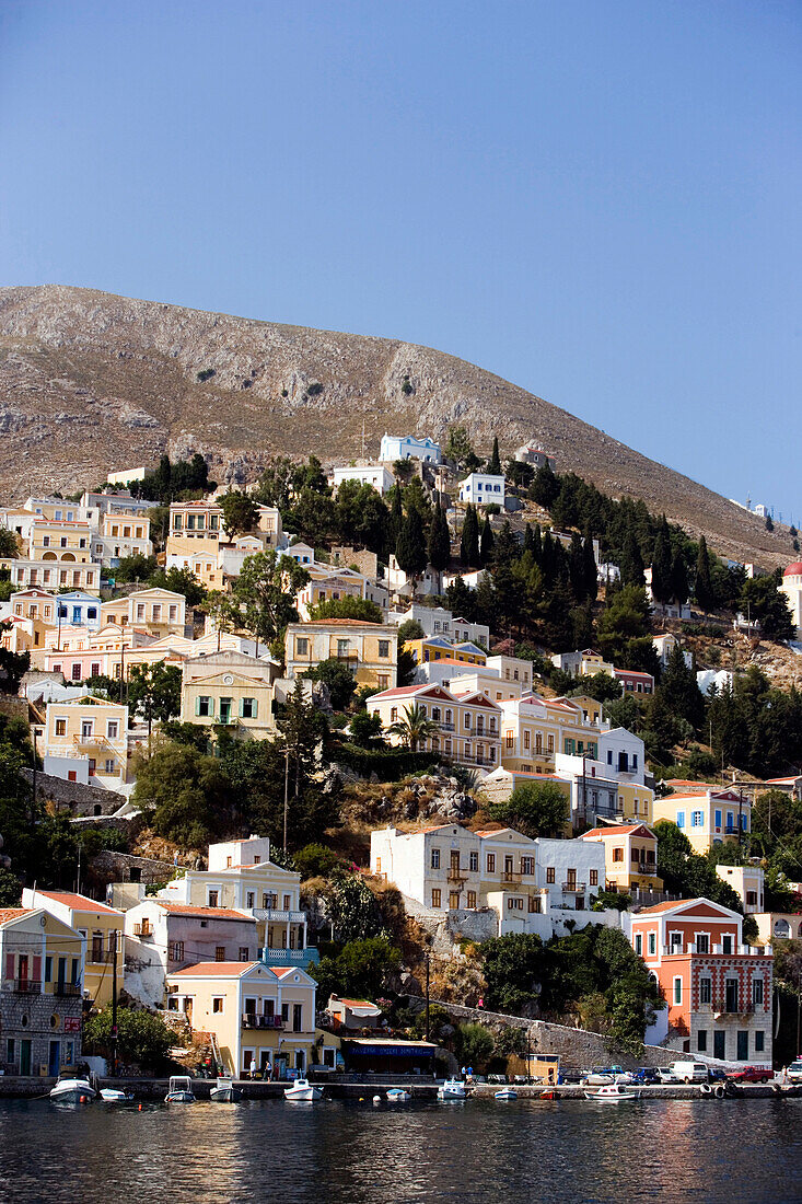View from Aegean Sea to a sea of houses at mountainside, Symi, Simi Island, Greece