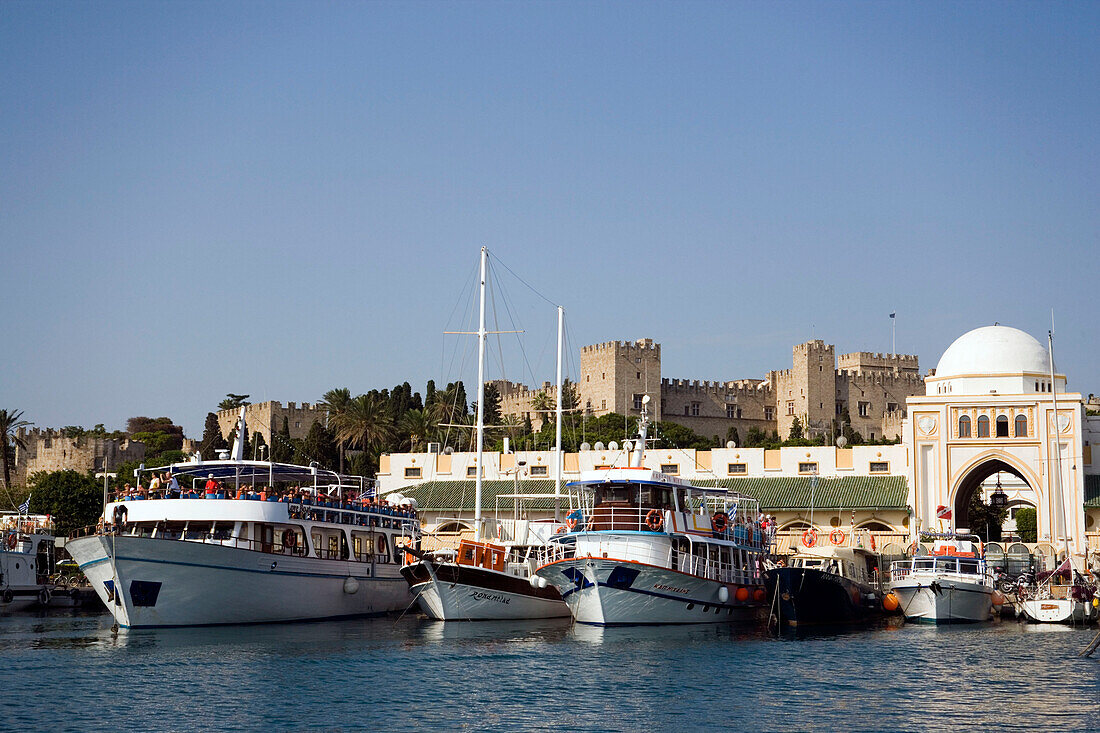 Ships and boats anchoring in Mandraki harbour (translated literally: fold), Palace of the Grand Master and Nea Agora in background, Rhodes Town, Rhodes, Greece