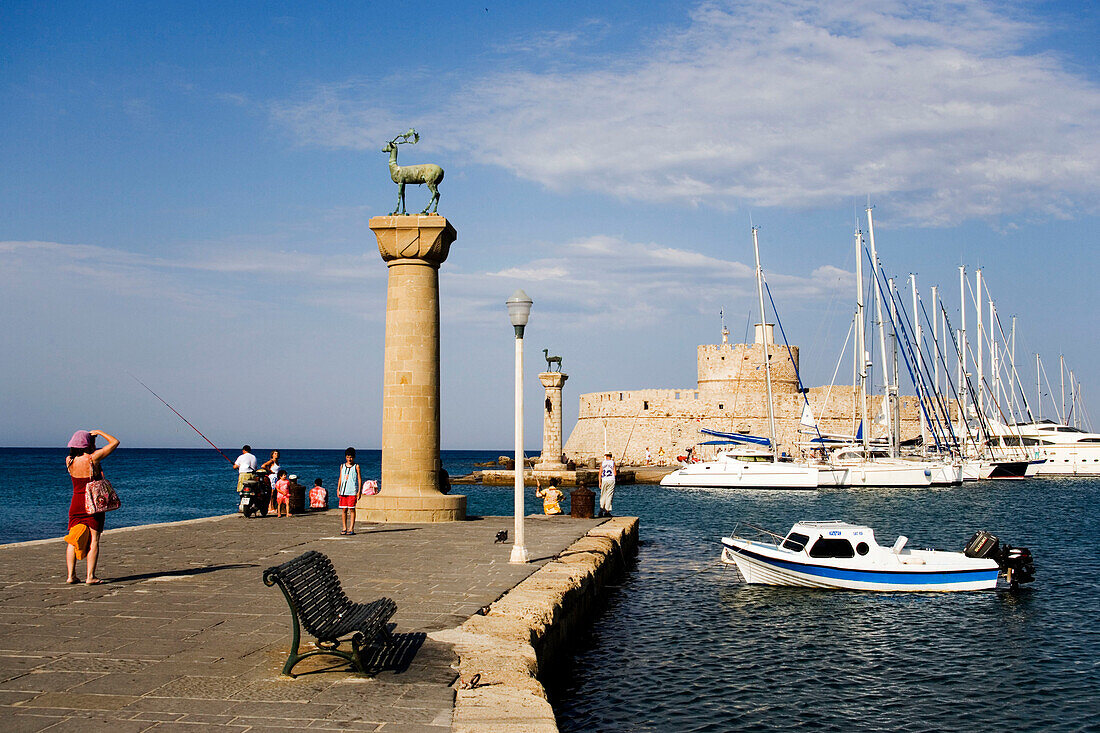 Columns with deer and doe (Elafos and Elafia) at port entrance of the Mandraki harbour (translated literally: fold), fortress tower Agios Nikolaos in background, Rhodes Town, Rhodes, Greece