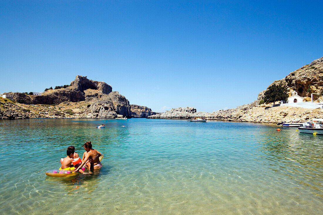 Mother and children bathing in the Saint Paul's Bay (Agios Pavlos), Lindos, Rhodes, Greece