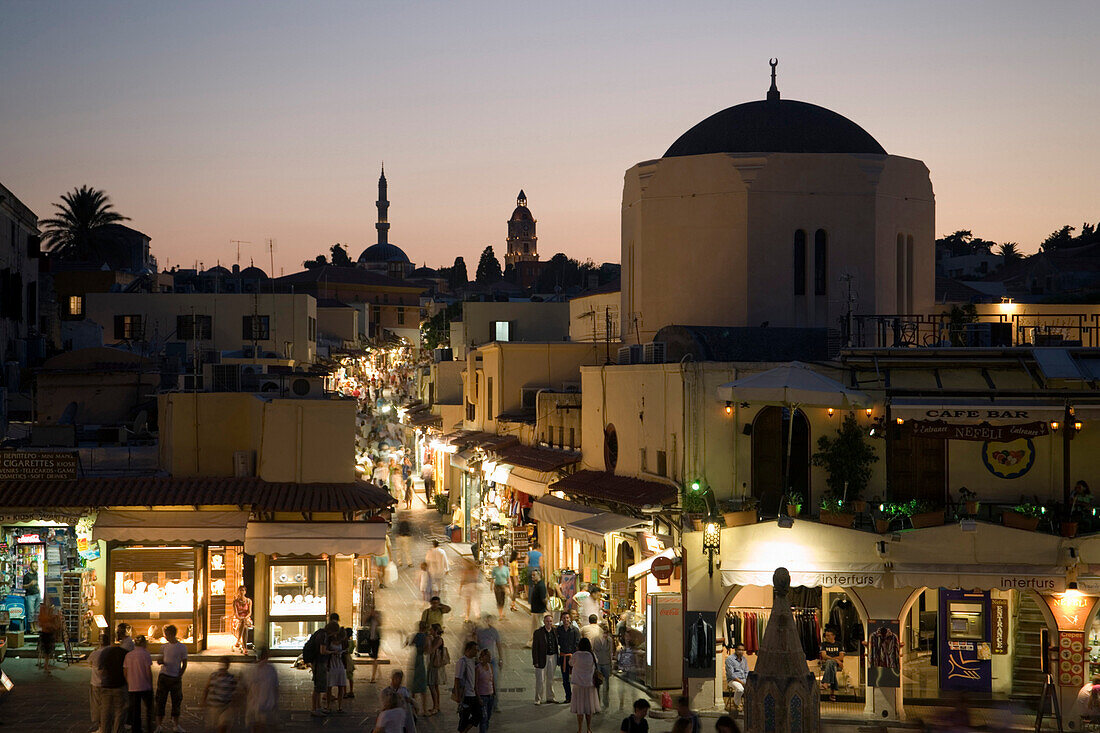 View over Platia Ippokratou into shopping street Odos Sokratous with Chadrevan mosque in the evening, Rhodes Town, Rhodes, Greece, (Since 1988 part of the UNESCO World Heritage Site)