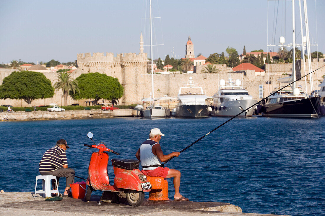 Two Greeks fishing at mole, Mandraki harbour (translated literally: fold), Rhodes Town, Rhodes, Greece