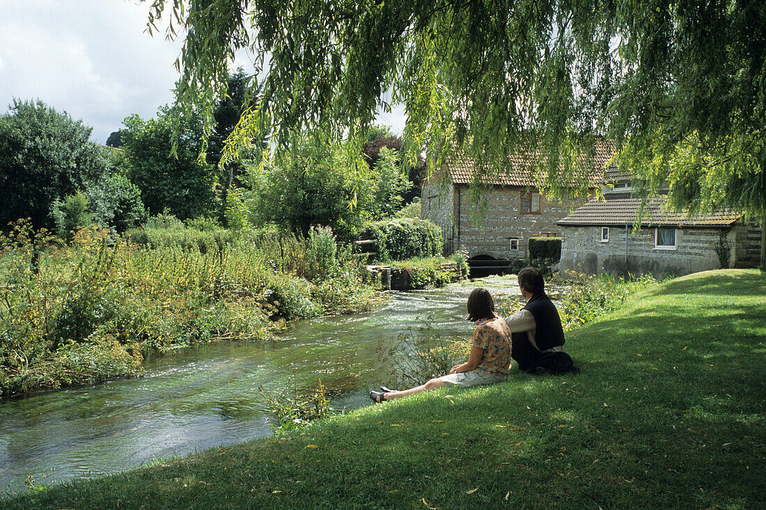 Zwei Menschen entspannen am Fluss, Godmanstone, Südengland, England, Großbritannien