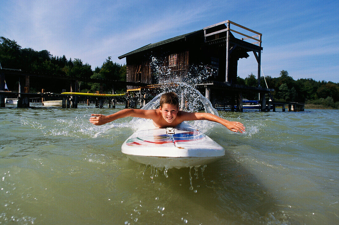 Boy with surfboard, Lake Ammersee, Upper Bavaria, Bavaria, Germany, Europe