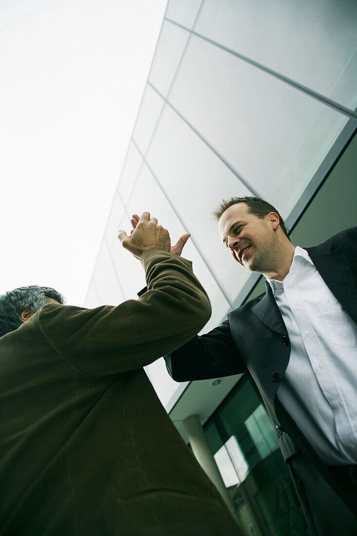 Two business men are pleased about a deal, give me five