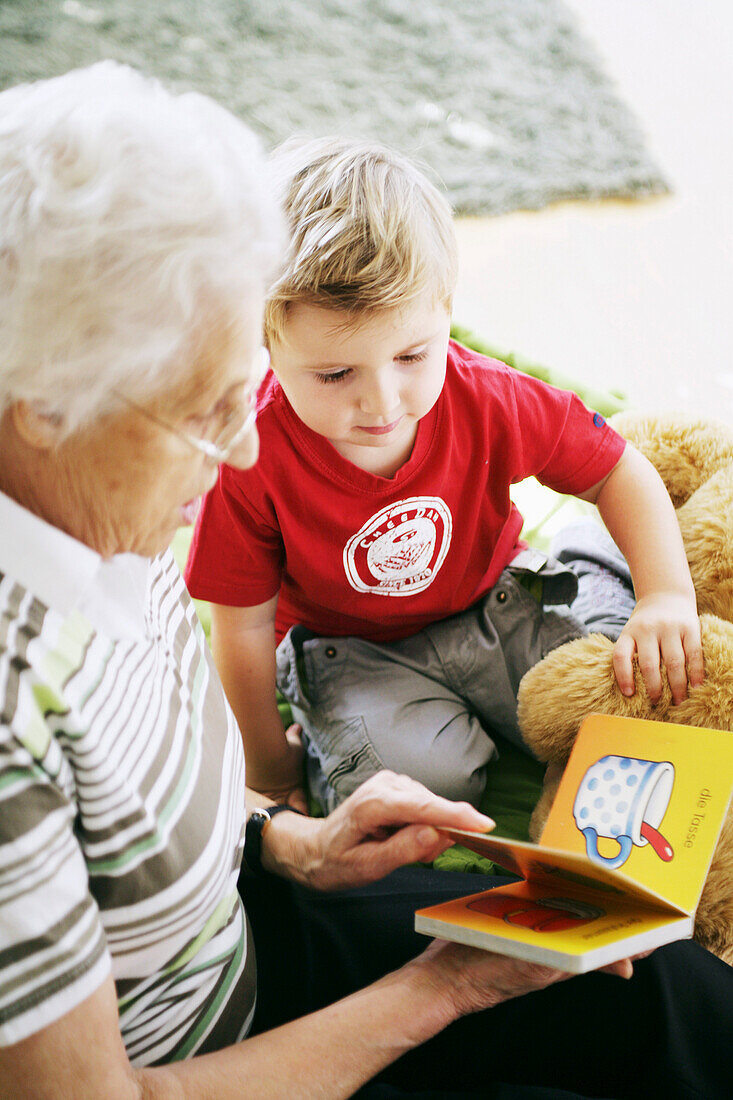 Grandmother and grandchild reading a book together