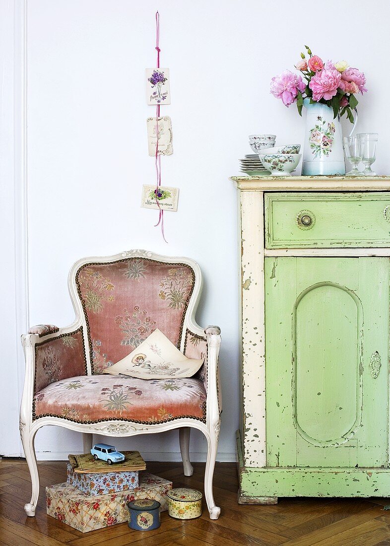 Baroque style chair next to a country style chest of drawers