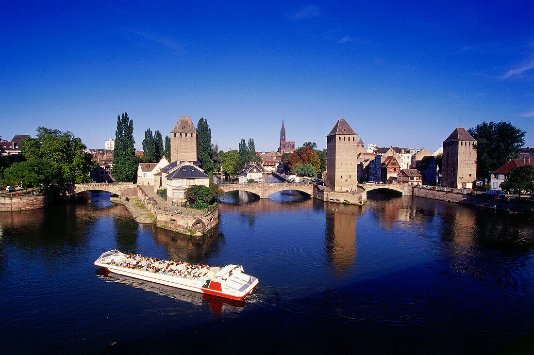 Ausflugsboot vor den Ponts Couverts unter blauem Himmel, Strassburg, Elsass, Frankreich, Europa